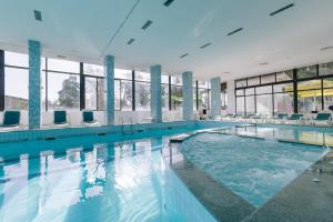 uma grande piscina com água azul num edifício em Eco Hotel Zdravetz em Zar-Kalojan