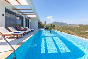 a swimming pool with a view of a house at Villa Luxe in Sivota