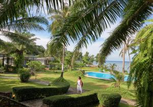 a woman walking down a path in front of a resort at Elephant Bay Resort in Ko Chang