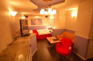 a small room with a red chair and a bed at Koriyama Aine Adult Only in Koriyama