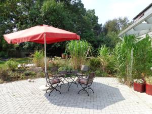 a table and chairs under an umbrella on a patio at Apartment Muschel im Gästehaus Heeren in Krummhörn