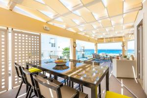 een eetkamer met een tafel en stoelen en de oceaan bij Radamanthy's Hotel Apartments in Sfakaki