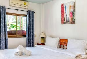 a bedroom with two beds and a window at Kata Leaf Resort Phuket - SHA Extra Plus in Kata Beach