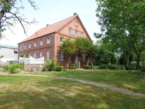 un gran edificio de ladrillo con un patio de césped en Apartment Muschel im Gästehaus Heeren, en Krummhörn