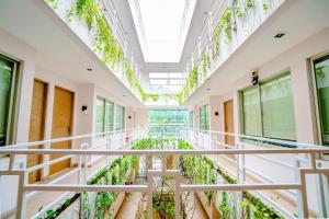 um corredor de um edifício com plantas verdes em LeGreen Suite Tondano em Jakarta