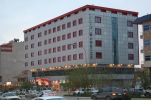 a large building with cars parked in a parking lot at Prizh Hotel in As Sulaymānīyah