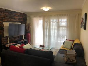a living room with a couch and a flat screen tv at Summer Sands - Durban North Beach Accommodation in Durban