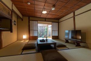 a living room with a television and a table at Gion Shirakawa Kouki Machiya House in Kyoto