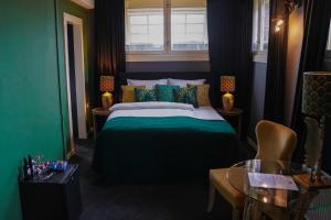 een groene slaapkamer met een bed en een raam bij Hotel Huis van Bewaring - Bijzonder boutique hotel in historisch pand in Almelo