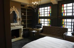 a bedroom with a bed and a fireplace and stained glass windows at Huis van Bewaring in Almelo