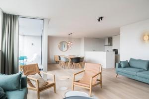 a living room with a blue couch and a table at Skyline Flats Gent in Ghent