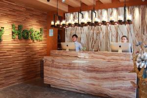 two people sitting at a counter with their laptops at Harbin Joy Boutique Hotel in Harbin