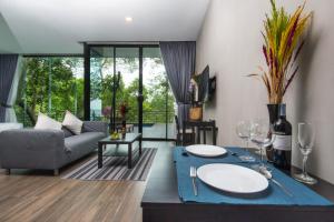 a living room with a couch and a table with wine glasses at Matina Mountain Resort in Koh Tao