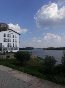Corabia的住宿－Hotel Sucidava，水体旁的白色大建筑