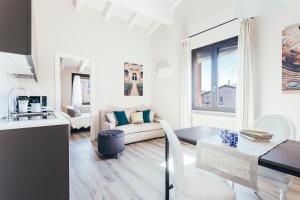 a white living room with a couch and a table at Opera Residence - by Bologna Residences in Bologna