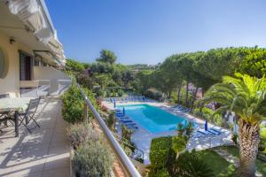 een balkon met uitzicht op het zwembad van een villa bij Appartamenti Residence il Porto 13 16 e 21 in Porto Azzurro