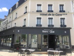 ラ・ロッシュ・シュル・ヨンにあるHôtel de la Gare - Restaurant Bistro Quaiのホテルドラケア(建物の前のテーブルと椅子付)
