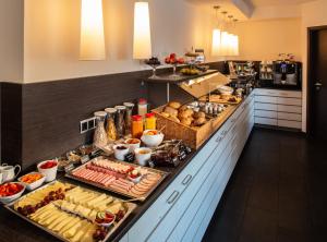 a buffet table filled with lots of different types of food at Bergers Airporthotel Memmingen in Memmingerberg