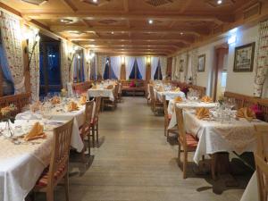 a dining room with tables with white tablecloths at Pension Ludwig Thoma in Otterfing
