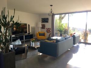 a living room with couches and a tv at Maison du bois Breton in Camblanes-et-Meynac