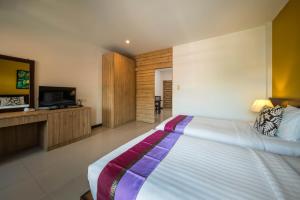 a bedroom with a large bed and a television at Kamala Beachfront Apartment in Kamala Beach