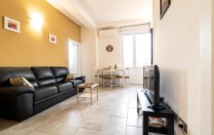 - un salon avec un canapé noir et une télévision dans l'établissement Relax suite belvedere, à Bologne