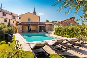 een zwembad met stoelen en een huis bij Villa Benvenuti in Motovun