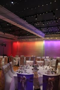 a dining room with white tables and a colorful wall at Manor Hotel in Exmouth