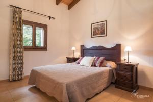 ein Schlafzimmer mit einem großen Bett und zwei Nachttischen in der Unterkunft Son March in Sa Pobla