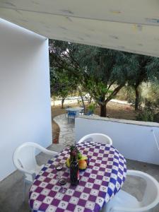 a table with a plate of fruit on a porch at Aggelos Studios in Agios Prokopios