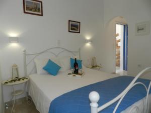 a bedroom with a white bed with blue pillows at Aggelos Studios in Agios Prokopios