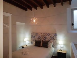 sypialnia z białym łóżkiem z 2 lampami w obiekcie Casas de Sevilla - Casa Sevillana Harinas26 w Sewilli +37 zdjęć