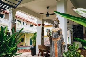 a statue in the courtyard of a house with plants at Residence Wat Damnak in Siem Reap