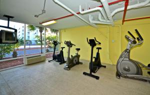 einen Fitnessraum mit mehreren Heimtrainern und einem TV in der Unterkunft Sunrise Suites Cat Island Suite #205 in Key West