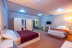 a hotel room with two beds and a desk at Meros Boutique Hotel in Samarkand