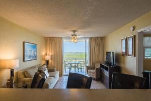 ein Wohnzimmer mit einem Sofa und einem Tisch mit Stühlen in der Unterkunft Sunrise Suites Panama Suite #310 in Key West