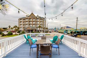 a deck with chairs and a table and a building at Midtown Paradise on the Beach in Galveston