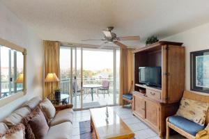 a living room with a couch and a tv at Sunrise Suites Paradise Escape #407 in Key West