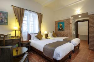 Rúm í herbergi á Thamel Villa Heritage Hotel
