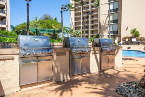 a grill with three burners next to a pool at Valley Isle Resort in Kahana