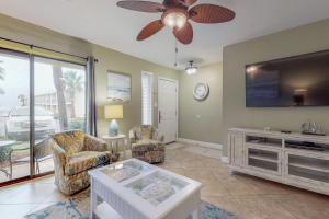 a living room with two chairs and a flat screen tv at Gulf Winds #39 in Destin