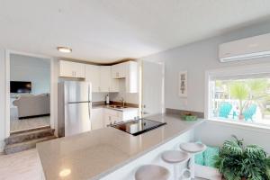 a kitchen with white cabinets and a white refrigerator at Midtown Paradise on the Beach in Galveston