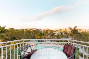 a balcony with a table and chairs and a view of the city at Sunrise Suites Paradise Escape #407 in Key West