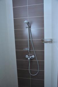 a shower with a hose in a bathroom at Tropicana Inn in Uralsk