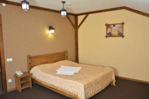 a bedroom with a bed with towels on it at Tropicana Inn in Uralsk