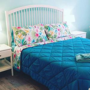1 dormitorio con cama azul y almohadas coloridas en Il Gatto Sulla Finestra, en Iesi