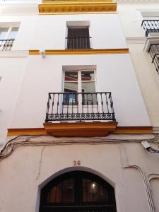 biały budynek z balkonem i oknem w obiekcie Casas de Sevilla - Casa Sevillana Harinas26 w Sewilli