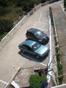 a black car parked in a parking lot at Nicolas Rooms in Fiskardo