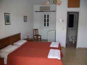 a bedroom with a large red bed in a room at Nicolas Rooms in Fiskardo