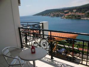 a balcony with a table and a view of the water at Nicolas Rooms in Fiskardo